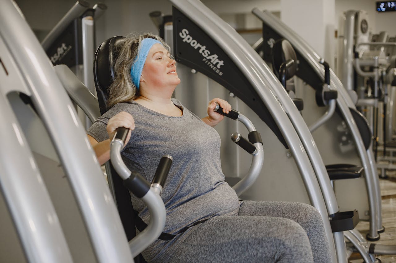 services-03 Plus size woman working out on gym equipment indoors, promoting health and wellness.